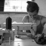 Esta imagen muestra a una persona trabajando con una máquina de coser en un taller.
